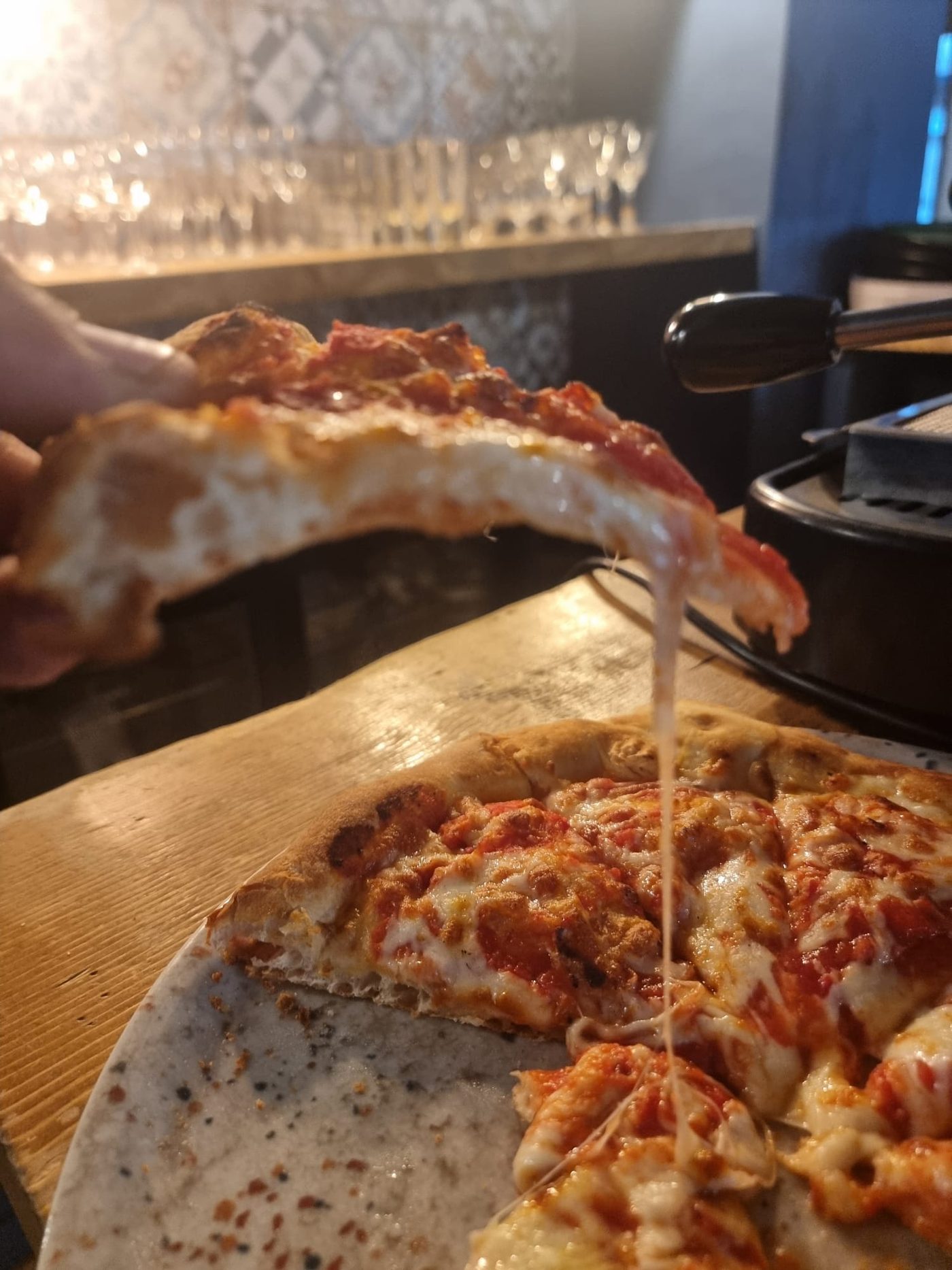 Pizza Margherita filante servita al bancone di VERO